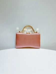 Detailed front view of pink satin evening clutch bag with elegant gold metal handle