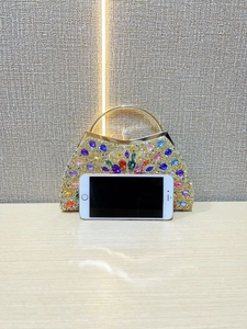 Detailed shot of sparkling rhinestone evening bag with colorful gems and gold handle