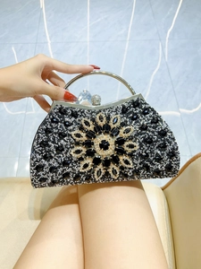 Detail of luxury rhinestone clutch bag with floral gemstone pattern and silver handle