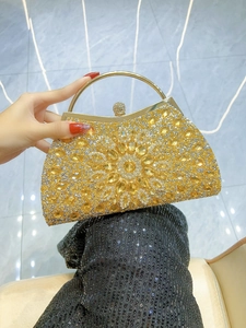Macro shot of gold evening clutch featuring radial crystal patterns and metal handle