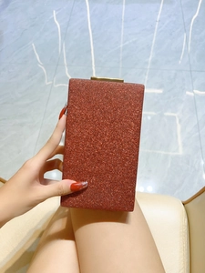 Détail des paillettes cuivrées scintillantes et du fermoir en métal doré de la pochette de soirée