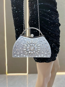Close-up of silver evening clutch bag with radiant rhinestone floral design and ring handle