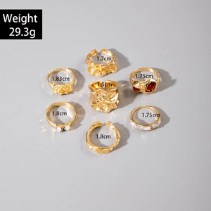 Lot de 7 bagues dorées avec pierres rouges, perles blanches et texture de lave