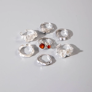 Lot de 7 bagues argentées style métal liquide avec ambre orange et détails en pierre blanche