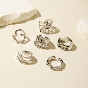 Détail d'un lot de 6 bagues argentées aux formes organiques irrégulières type lave