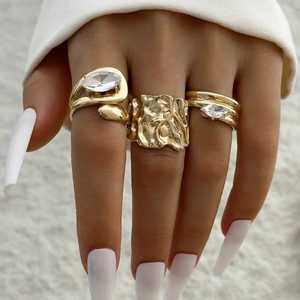 Ensemble de trois bagues dorées avec texture métal liquide et zircon taille marquise
