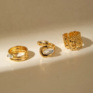Ensemble de trois bagues dorées géométriques avec pierres zircon et texture irrégulière