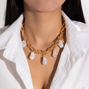 Chunky gold chain necklace with five baroque pearl pendants on a fashion model