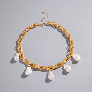 Detailed view of gold chain necklace with baroque pearls and lobster clasp closure