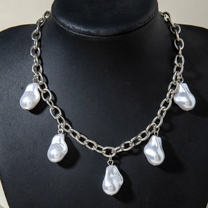 Close-up of silver chain choker featuring five baroque pearls on a black display neck