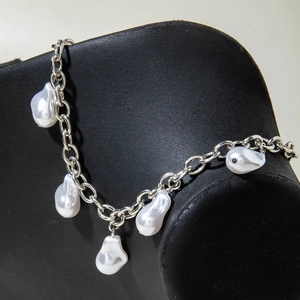 Silver chain bracelet with five lustrous white baroque pearls on a black display stand