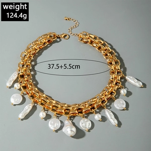 Close-up of gold chunky chain necklace with hanging baroque pearls and round beads