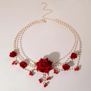 Détails macro de la chaîne multicouche en perles avec roses rouges et fermoir doré