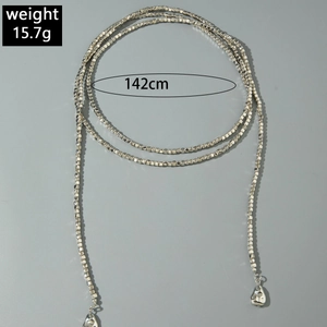 Detalle de un collar largo de 142 cm con cuentas plateadas y colgantes de gota