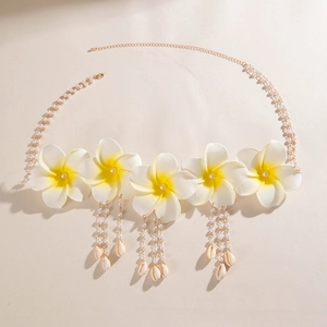Détail de chaîne de taille avec fleurs de frangipanier, glands en perles et coquillages