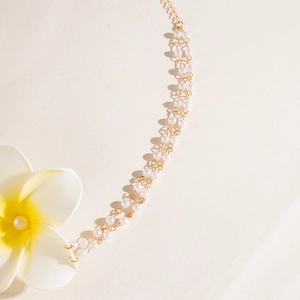 Détail d'un collier de perles à plusieurs rangs avec un pendentif fleur de frangipanier