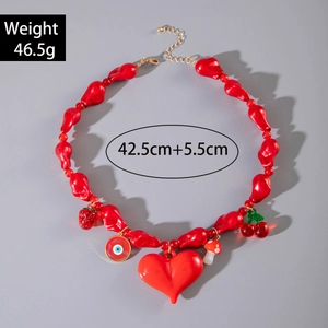 Vue détaillée du collier de perles rouges avec pendentifs cœur, cerise et œil en résine