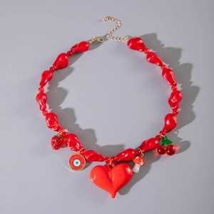 Détail du collier de perles rouges avec pendentifs cœur, fraise et mauvais œil