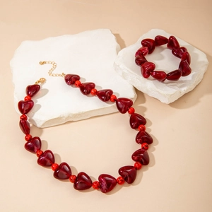 Détail de perles cœur en résine rouge et ensemble de collier sur socles en pierre