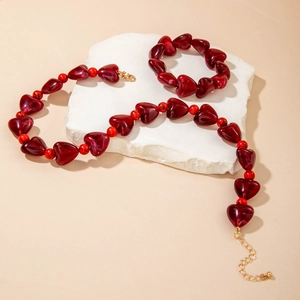 Vue détaillée de l'ensemble collier et bracelet en perles de cœur rouges et fermoir doré