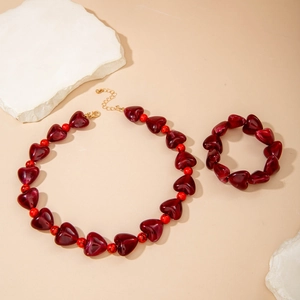 Détail de perles de cœur en résine rouge et sphères marbrées sur le collier