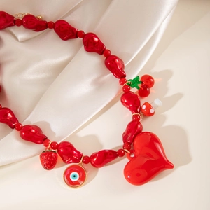Collier de perles rouges avec breloques cœur, cerise, fraise et œil sur soie