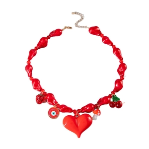 Collier de perles rouges avec breloques cœur, cerise et œil sur fond blanc