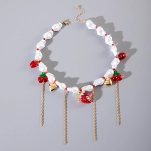 Collana con perle barocche, ciondoli a fragola e ciliegia e nappe a cuore su sfondo grigio