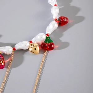 Collana con perle barocche ciondoli a fragola e ciliegia con cuore su sfondo grigio