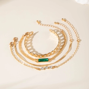 Five-piece gold bracelet set with green emerald-cut stone and twist chain details