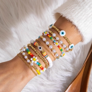 Close-up of bohemian multi-layer beaded bracelets with evil eye charms on a model wrist