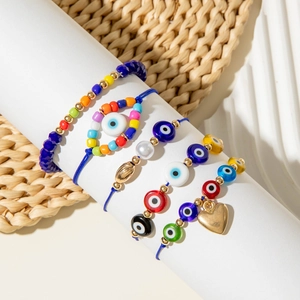 Close-up of Bohemian evil eye beaded bracelets with gold heart charm and colorful beads