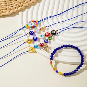 Detail of 5-piece Bohemian evil eye beaded bracelet set with blue cords and heart charm