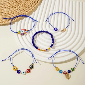 Detail of five bohemian blue evil eye bracelets with beads and charms on a display tray