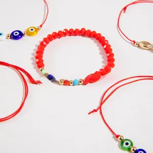 Close-up of bohemian red beaded bracelets with evil eye charms and gold accents