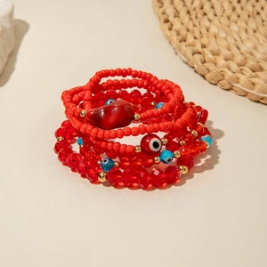 Detail of red Bohemian beaded bracelet set featuring Evil Eye charms and heart pendant