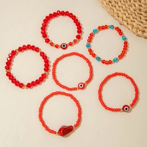 Detail of bohemian red beaded bracelet set featuring evil eye charms and faceted crystals