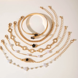 Seven-piece gold fashion jewelry set with evil eye, flower, and faux pearl bracelets