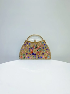 Macro shot of colorful rhinestones and crystal flower pattern on a golden clutch