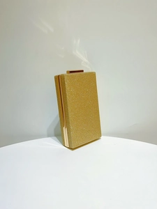 Détail de la pochette de soirée dorée pailletée avec cadre et fermoir métallique