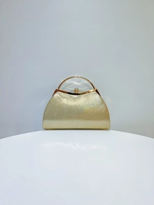 Detailed macro view of the golden glitter texture and metallic ring handle on evening bag