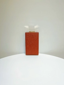 Détail d'une pochette de soirée à paillettes rouge rouille avec fermoir doré