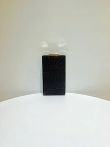Détail d'une pochette de soirée noire pailletée avec fermoir doré métallique chic