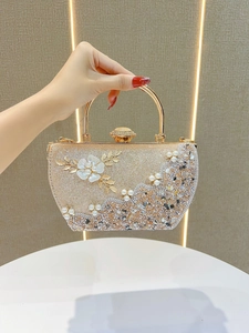 Détail de la pochette de soirée dorée avec fleurs 3D en nacre et décorations de perles