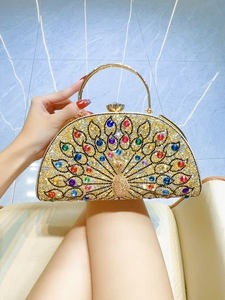 Close-up of peacock-shaped evening clutch with colorful rhinestones and gold handle