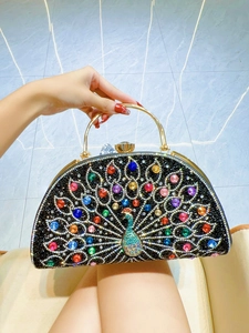 Detailed close-up of a peacock evening bag featuring colorful rhinestones and gold handle