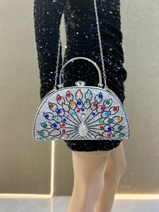 Detail of peacock crystal evening bag featuring multicolored rhinestones and metal handle