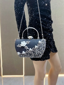 Détails de la pochette de soirée noire à paillettes, camélia blanc, perles et strass