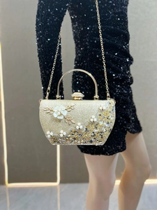 Détail de pochette de soirée champagne avec fleurs en relief et perles scintillantes