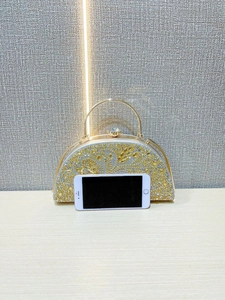 Detailed view of luxury evening handbag with gold and silver crystal leaf patterns
